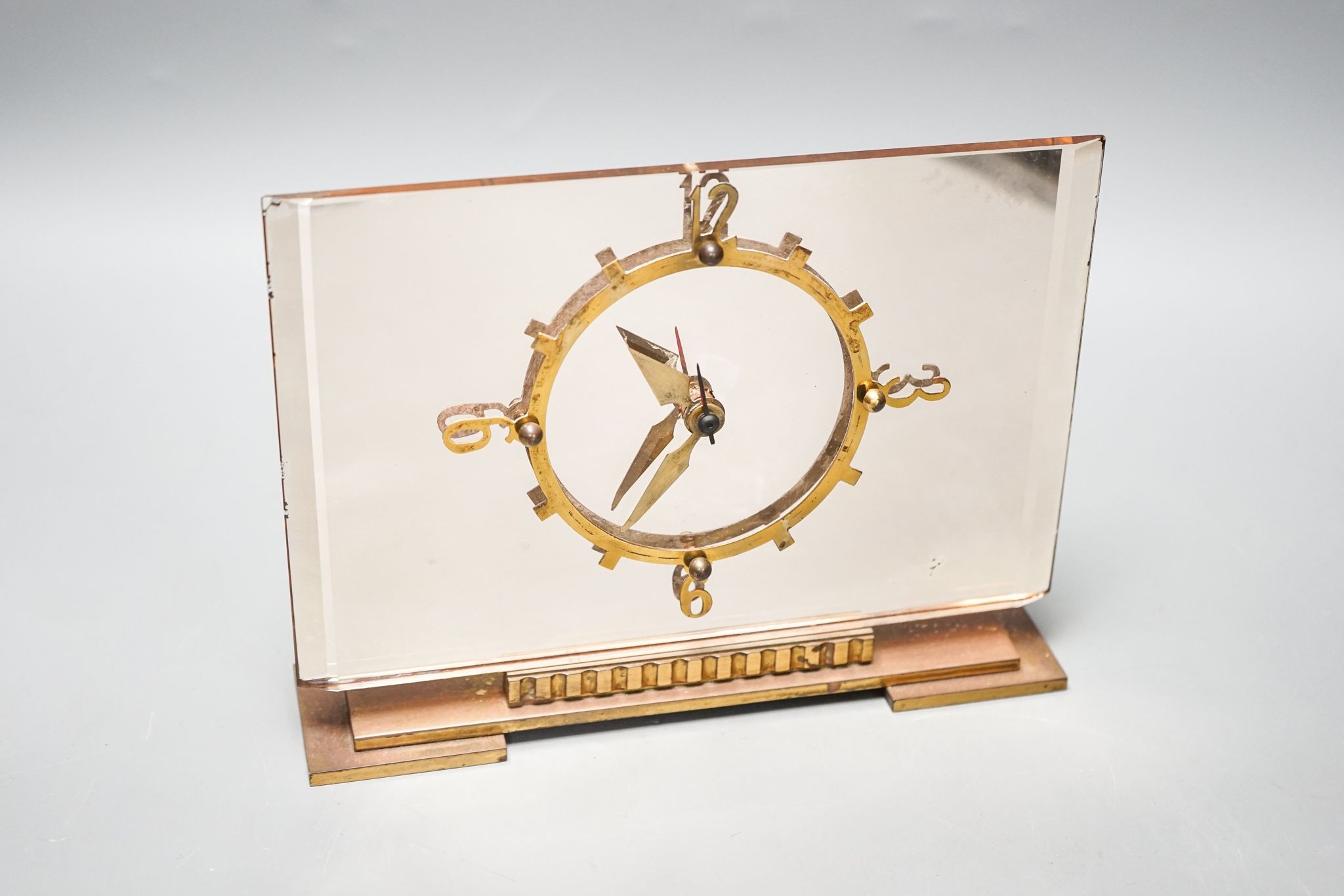 An Art Deco pink tinted glass electric mantel clock 22cm